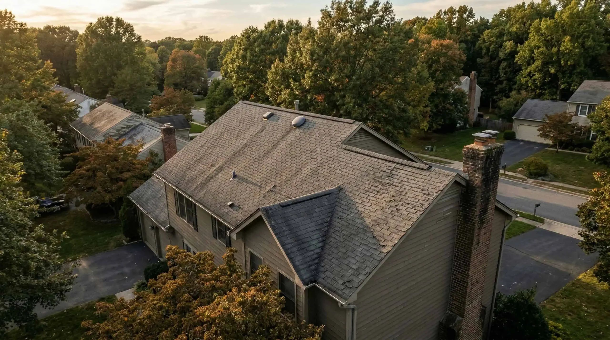 Weathered residential roof showing multiple signs of wear and aging